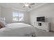 Bright bedroom featuring a ceiling fan, tray ceiling, and large window with natural light at 517 Edenfield Dr, Fuquay Varina, NC 27526