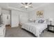 Spacious bedroom with a tray ceiling, ceiling fan, and an open door to the bathroom at 517 Edenfield Dr, Fuquay Varina, NC 27526