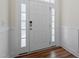 Bright entryway with natural light, wainscoting, and stylish white door with glass panels at 517 Edenfield Dr, Fuquay Varina, NC 27526