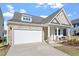 Two-car garage with stone accents and spacious driveway of this lovely home with a cozy front porch at 517 Edenfield Dr, Fuquay Varina, NC 27526