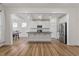 Bright kitchen featuring white cabinets, an island, stainless steel appliances, and an open layout to the dining area at 517 Edenfield Dr, Fuquay Varina, NC 27526
