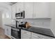 Kitchen featuring stainless steel appliances, granite countertops, and white cabinets at 517 Edenfield Dr, Fuquay Varina, NC 27526