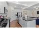 Modern kitchen with stainless steel appliances, island with sink, and open floor plan connecting to the living room at 517 Edenfield Dr, Fuquay Varina, NC 27526