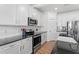 White kitchen cabinets featuring granite countertops, stainless steel appliances, and a white subway tile backsplash at 517 Edenfield Dr, Fuquay Varina, NC 27526