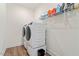 Modern laundry room showcasing a stacked washer and dryer, plus overhead storage shelves at 517 Edenfield Dr, Fuquay Varina, NC 27526