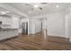 Open-concept living area with hardwood floors, stainless steel appliances, and a seamless flow into the entryway at 517 Edenfield Dr, Fuquay Varina, NC 27526