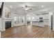 Bright living room featuring a fireplace, wood floors, and an open layout flowing into the kitchen and dining area at 517 Edenfield Dr, Fuquay Varina, NC 27526