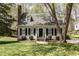 Charming two-story home features a brick chimney, dormer windows, and landscaped yard with fresh green grass at 520 Tall Oaks Dr, Durham, NC 27713