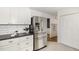 Stylish kitchen featuring stainless steel refrigerator, white cabinets, and ample counter space, connecting seamlessly to other spaces at 520 Tall Oaks Dr, Durham, NC 27713