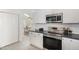 Bright kitchen with stainless steel appliances, white cabinets, tile floors, and open layout to adjacent dining area at 520 Tall Oaks Dr, Durham, NC 27713