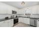 Well-equipped kitchen with white cabinets, stainless steel appliances, and tile flooring, offers a modern aesthetic at 520 Tall Oaks Dr, Durham, NC 27713