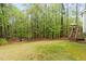 Expansive backyard with mature trees, fire pit, and space for outdoor activities at 5405 Whisperwood Dr, Durham, NC 27713