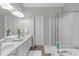 Bright bathroom featuring a double vanity, a soaking tub, and glass enclosed shower at 5405 Whisperwood Dr, Durham, NC 27713