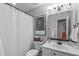 Bathroom featuring a shower with a white curtain, a toilet, a white sink, and decorative art at 5405 Whisperwood Dr, Durham, NC 27713