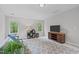 Bedroom featuring a TV on a stand, three windows, a gray sofa, and a patterned rug at 5405 Whisperwood Dr, Durham, NC 27713