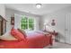 Cozy bedroom featuring a window with white shutters, a red table, and neutral paint at 5405 Whisperwood Dr, Durham, NC 27713