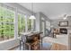 Bright breakfast nook featuring a modern table set, many windows and view of backyard at 5405 Whisperwood Dr, Durham, NC 27713