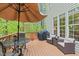 Relaxing deck area with umbrella-covered table, grill, and comfortable seating, perfect for outdoor entertaining at 5405 Whisperwood Dr, Durham, NC 27713