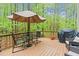 A wood deck with a table and umbrella and a view of the forest at 5405 Whisperwood Dr, Durham, NC 27713