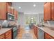 Bright eat-in kitchen featuring stainless steel appliances, wooden cabinets and a view of the windowed breakfast nook at 5405 Whisperwood Dr, Durham, NC 27713