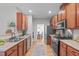 Galley kitchen with stainless steel appliances and natural wood cabinets overlooking an eat in dining room at 5405 Whisperwood Dr, Durham, NC 27713