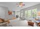 Open-concept living room adjacent to an eat-in kitchen featuring large windows and hardwood floors at 5405 Whisperwood Dr, Durham, NC 27713