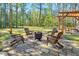 Backyard patio features a fire pit with Adirondack chairs in a charming outdoor setting at 55 Northdale Ct, Louisburg, NC 27549