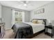 Cozy bedroom with a ceiling fan, large window, and a comfortable bed with stylish pillows at 55 Northdale Ct, Louisburg, NC 27549