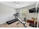 Bright bedroom featuring exercise equipment, including a treadmill, weight bench, and dumbbell rack at 55 Northdale Ct, Louisburg, NC 27549