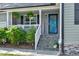 Inviting front porch with decorative plants, a stone staircase, and a blue front door at 55 Northdale Ct, Louisburg, NC 27549