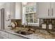 Bright kitchen features granite counters, stylish backsplash, and a view of the outdoors through the window at 55 Northdale Ct, Louisburg, NC 27549
