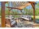 Outdoor patio area features elegant seating beneath a wooden pergola, perfect for entertaining guests at 55 Northdale Ct, Louisburg, NC 27549
