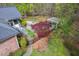 Aerial view of a brick home's landscaped backyard, including a stone patio and pergola at 5900 Orchid Valley Rd, Raleigh, NC 27613