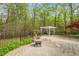 Stone patio with pergola surrounded by wooded area, ready for relaxing or entertaining at 5900 Orchid Valley Rd, Raleigh, NC 27613