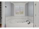 Comfortable bathroom with a large soaking tub and shuttered window at 5900 Orchid Valley Rd, Raleigh, NC 27613