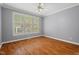 Bedroom featuring hardwood floors, wide windows with shutters, and neutral paint at 5900 Orchid Valley Rd, Raleigh, NC 27613