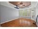 Cozy bedroom with tray ceiling, hardwood floors, and natural light from large windows at 5900 Orchid Valley Rd, Raleigh, NC 27613