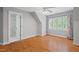 Light bedroom with a ceiling fan, a large window with wooded views, and gray walls for a calm feeling at 5900 Orchid Valley Rd, Raleigh, NC 27613