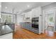 Open kitchen with gray cabinets, stainless appliances, granite countertops, and hardwood floors at 5900 Orchid Valley Rd, Raleigh, NC 27613