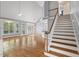 Open living room boasting hardwood floors, large windows, and a staircase at 5900 Orchid Valley Rd, Raleigh, NC 27613