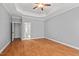 Large bedroom with tray ceiling, hardwood floors, and neutral paint at 5900 Orchid Valley Rd, Raleigh, NC 27613