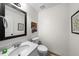 A bathroom vanity with a white sink and a large black framed mirror above a toilet at 6102 Coronado Ln, Durham, NC 27713