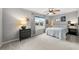 Bright bedroom features a ceiling fan, a bedside table lamp, and large window allowing natural light at 6102 Coronado Ln, Durham, NC 27713