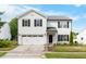 Charming two-story home with a well-maintained lawn, two-car garage, and classic black and white color scheme at 6102 Coronado Ln, Durham, NC 27713