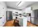 Modern kitchen featuring white cabinets, granite countertops, stainless steel appliances, and a central island at 6102 Coronado Ln, Durham, NC 27713