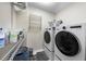 Laundry room features a modern washer and dryer with storage shelving and space saving towel rack at 6102 Coronado Ln, Durham, NC 27713