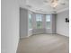 Spacious main bedroom with neutral carpet, ceiling fan, tray ceiling, and large windows at 611 Atticus Way, Durham, NC 27703