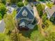 Aerial view of a large home with a stone patio, mature landscaping, and a well-manicured lawn at 642 Bear Tree Creek, Chapel Hill, NC 27517
