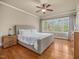 Bright bedroom featuring a ceiling fan, large windows, and hardwood floors at 642 Bear Tree Creek, Chapel Hill, NC 27517