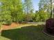 Well-maintained front yard featuring lush green grass, mature trees, and manicured landscaping at 642 Bear Tree Creek, Chapel Hill, NC 27517